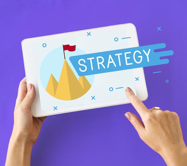 Instant Marketing Milano Italian’s Edition: mano che tengono un tablet mentre fa vedere il concetto di strategia attraverso i
